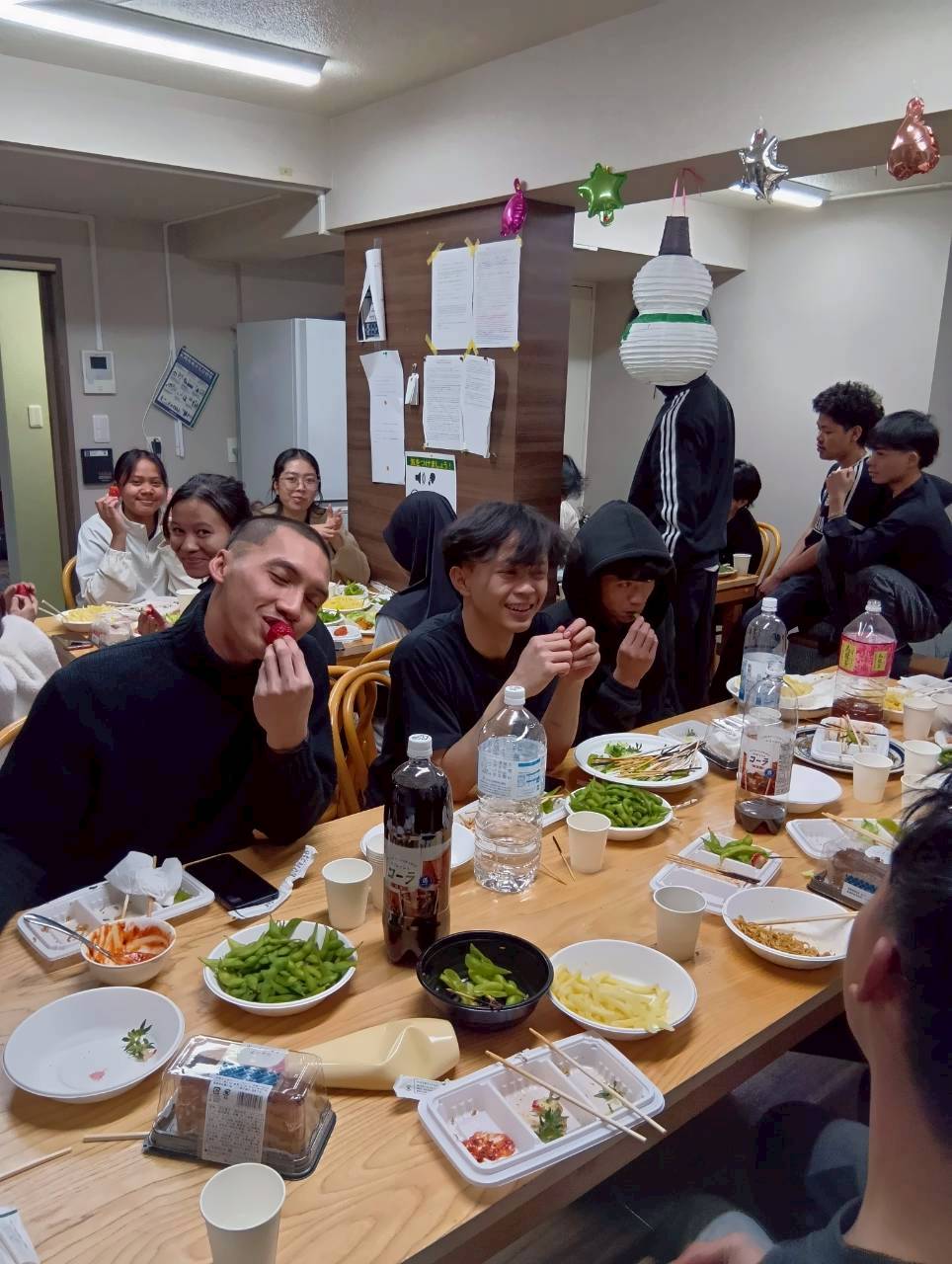 山の手寮の誕生日会でケーキを囲むスタッフたちの笑顔