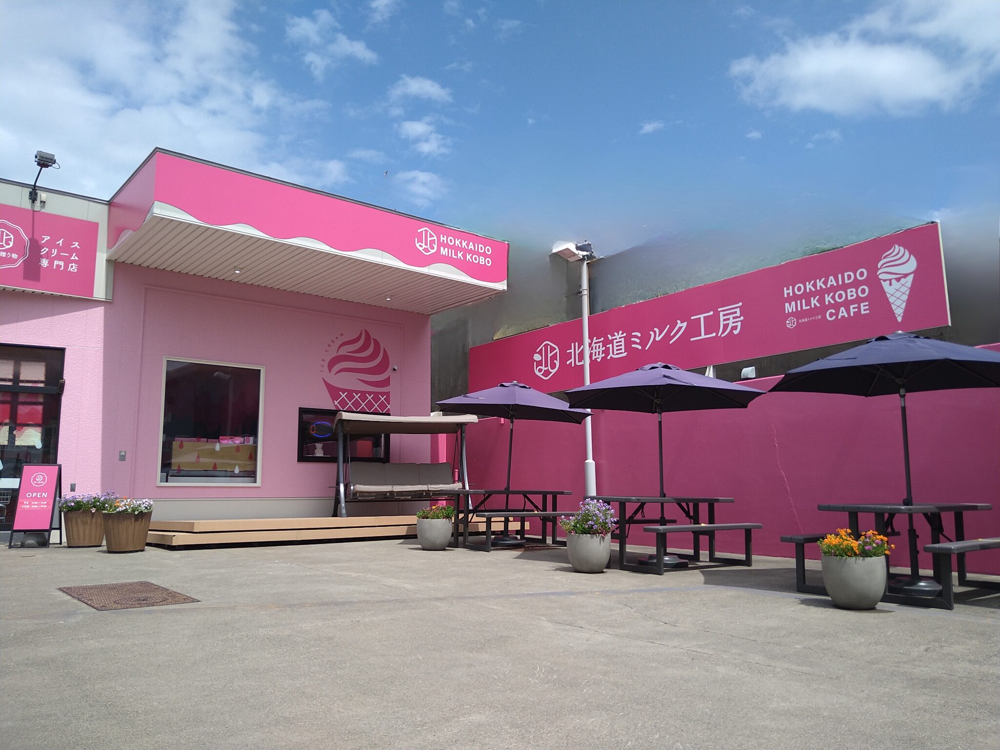 北海道ミルク工房CAFE 永山店の外観・ピンクの建物とソフトクリームの看板