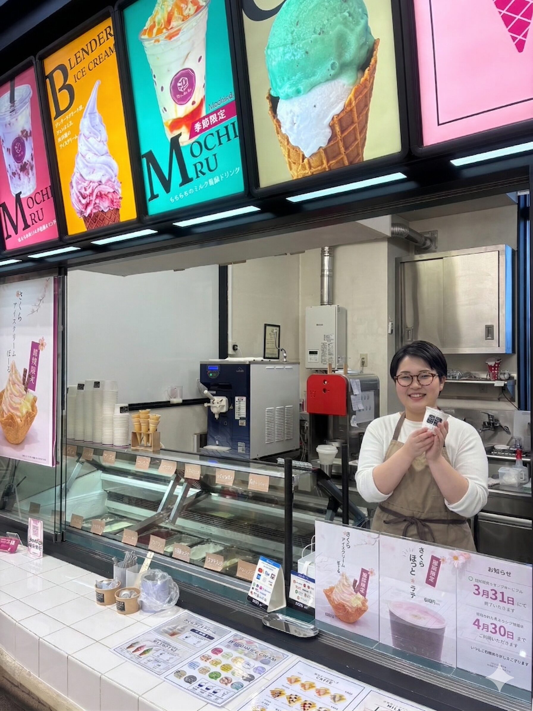 カラフルなメニューボードと販売カウンター前に立つスタッフ・店舗の雰囲気